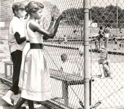 Pool Segregation - two Black girls staring at pool through chain link fence